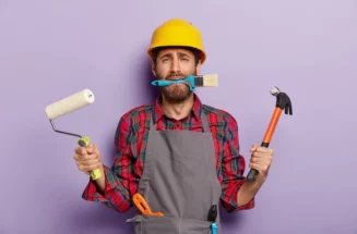 busy-repairman-holds-building-tools-does-repairing-at-home-wears-yellow-hardhat-apron-stands-indoor_273609-32543.webp