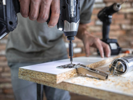 screwing-self-tapping-screw-into-metal-fastening-hole-wood-strip-using-screwdriver-work-carpenter